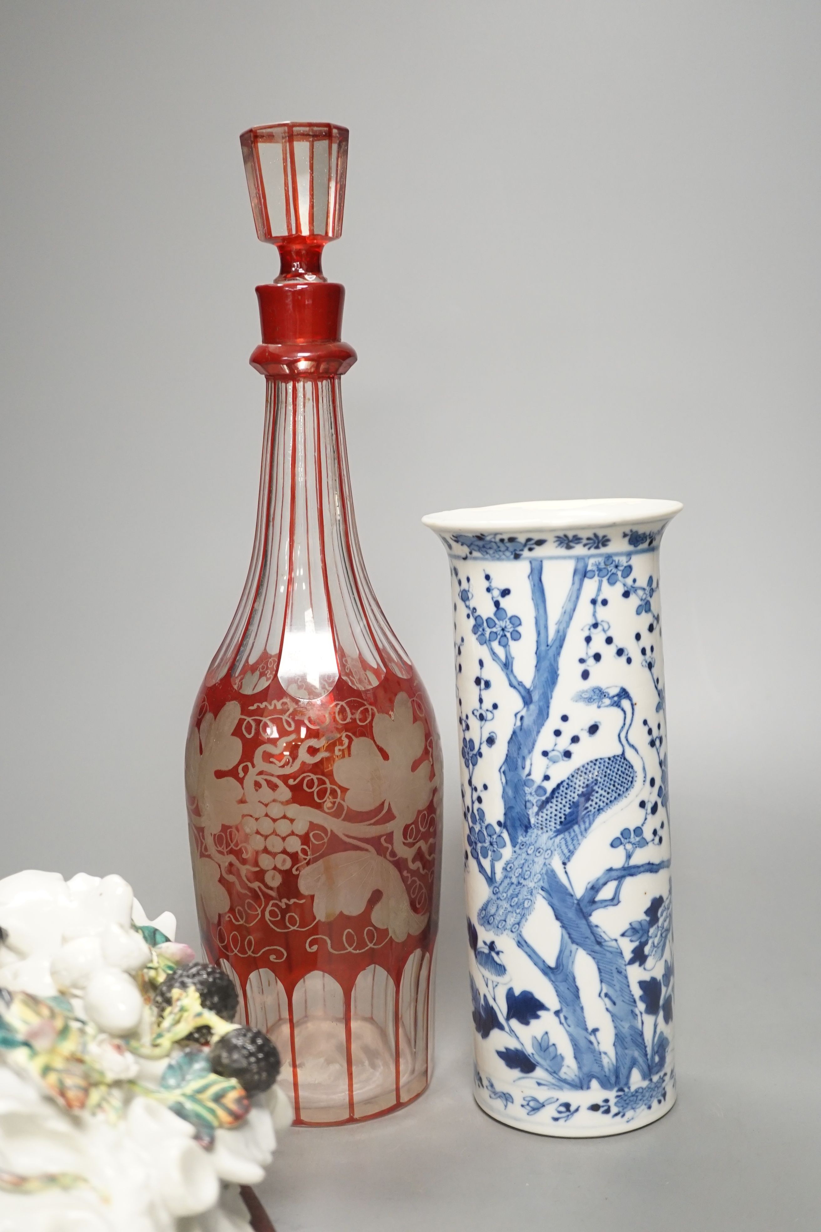 An etched ruby glass decanter, a Chinese blue and white sleeve vase and a continental ceramic basket wall pocket- decanter 34cms high.